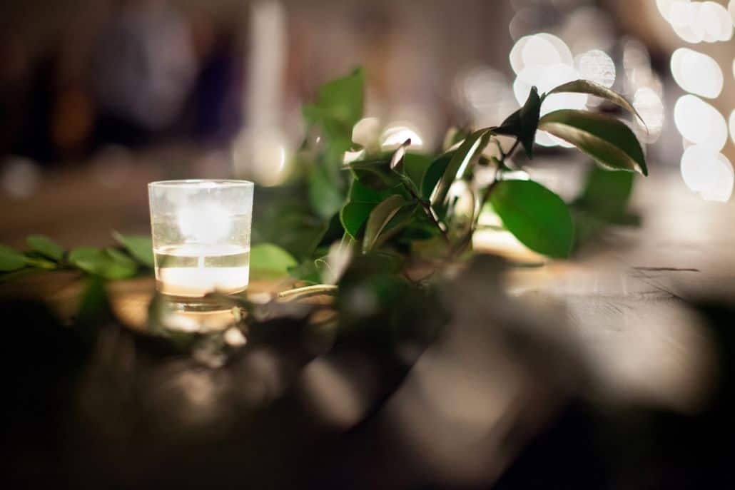 close up wedding photo of tea light candle and green foliage at the green building in brooklyn NY. Evening wedding photography, new york wedding photographer. flower wholesaler, flower district, manhattan. DIY wedding flowers.