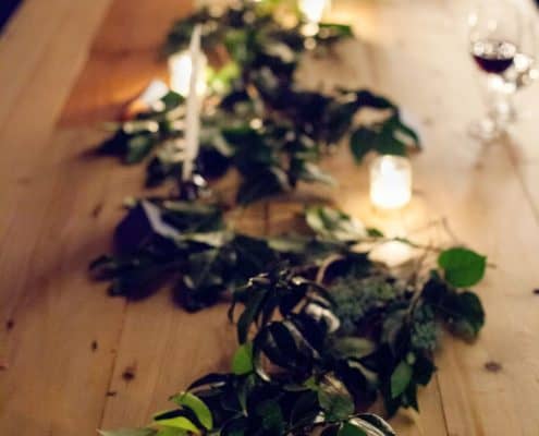 green leaves and tea lights on bare wood knotty table at the green building wedding reception, brooklyn NY. flower wholesaler, manhattan flower district, new york wedding photographer. DIY wedding flowers.