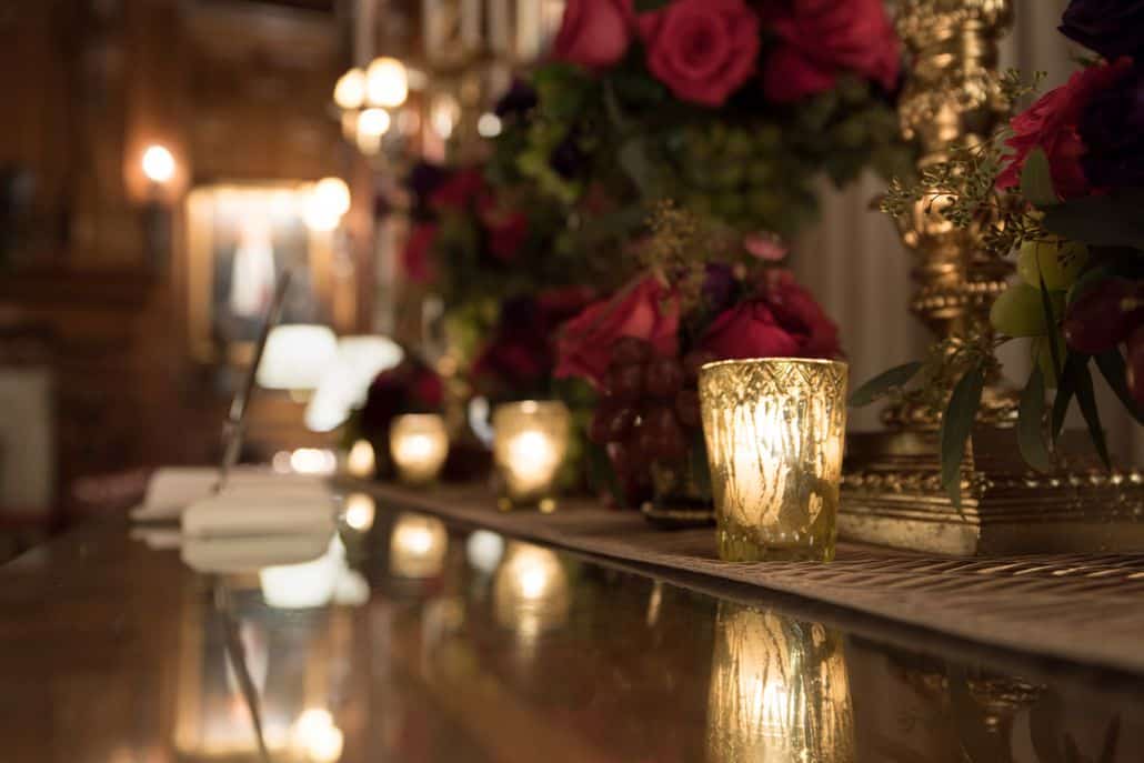 deep pink rose floral arrangements with grape and antiqued gold accents at Lotos club NYC, guest book, antiqued gold tealight candles. New York wedding photographer.