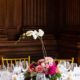 white orchid in center of pink and fuscia wedding table centerpiece, white linens, gold chiavari chairs, formal wood paneled walls, Karen Brown Events NYC wedding photographer.