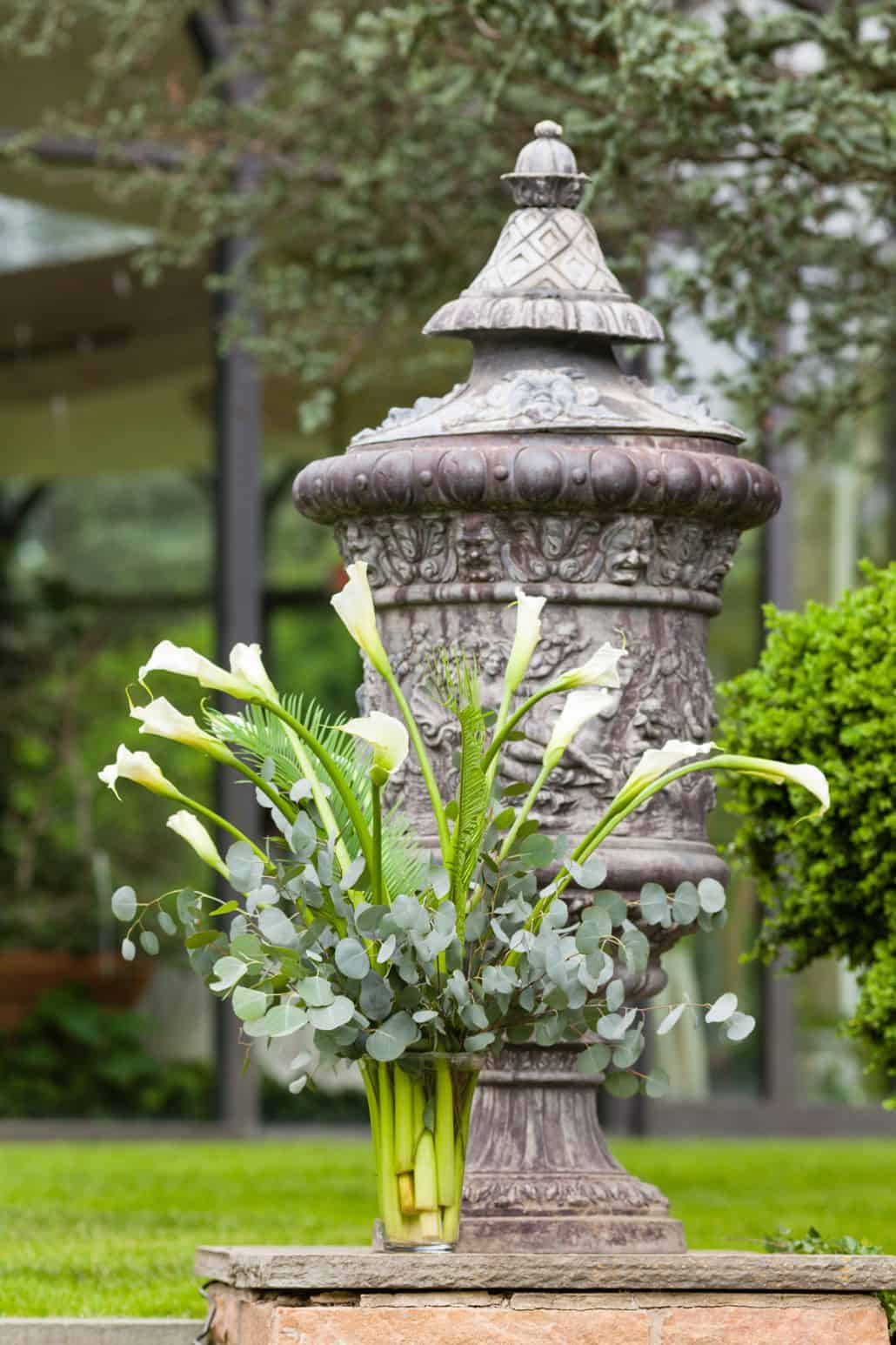 Calla Lily, fern and eucalyptus floral arranement in front of large urn at Jasna Polana wedding, Princeton, NJ. Janet Makrancy's weddings and parties florist. New Jersey wedding photographer.