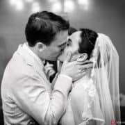 black and white photo of bride and groom's first kiss as man and wife. Bride's hair braided crown. NYC City Hall elopement photographer. Summer NYC wedding photo.