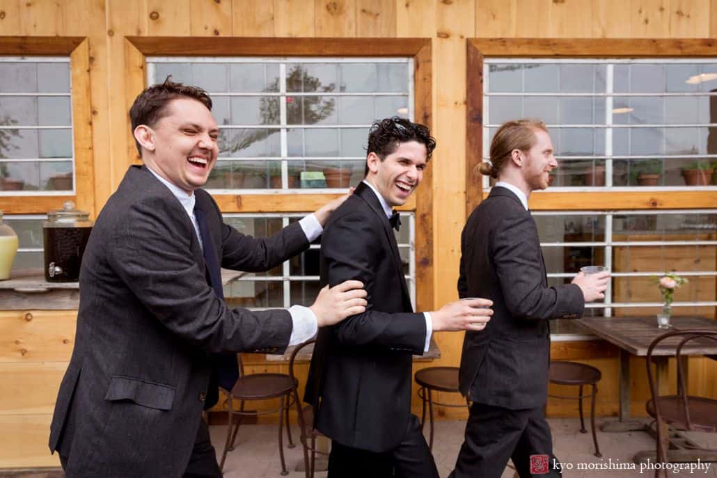 groomsmen laugh and walk with groom at Blooming Hill Farm wedding. Charcoal gray groomsmen suits. June NYC rainy day wedding. Blooming Hill Farm Wedding photographer Village Tea Room Cartwright Tents West Point Tours West Philadelphia Orchestra Hudson Valley Ceremonies Designer Loft Catbird Catherine Angiel 