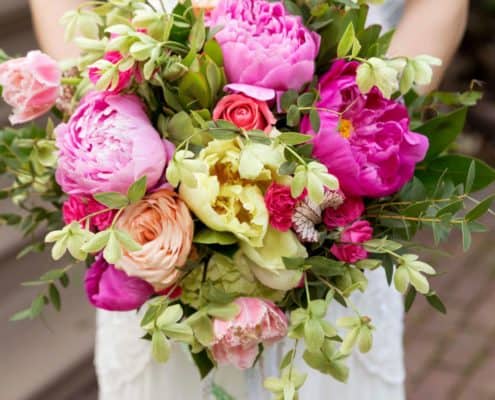 bride holds pink, yellow and fuscia bridal bouquet, peonies, roses, hydrangea, Kristin Rockhill florist, Nassau Inn, Princeton, NJ wedding photographer.
