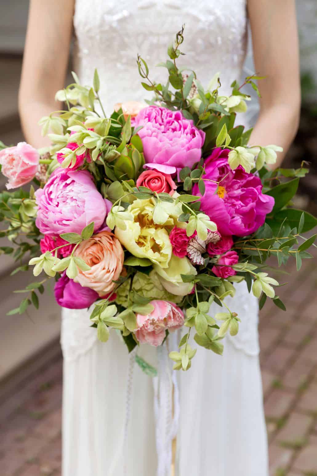 bride holds pink, yellow and fuscia bridal bouquet, peonies, roses, hydrangea, Kristin Rockhill florist, Nassau Inn, Princeton, NJ wedding photographer.