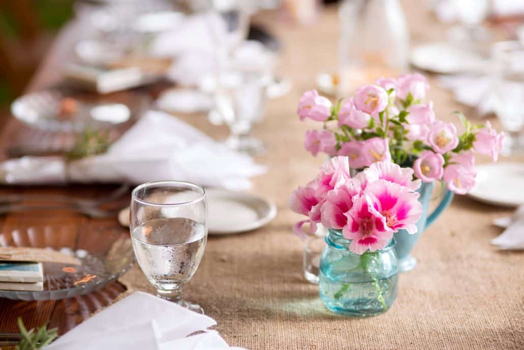 pink canterbury bells and fuscia center flowers in turquoise mug and small mason jar on burlap table runner and dark wood table, white napkins, Stem Cut Flowers florist, Lake Geneva, WI wedding photographer.
