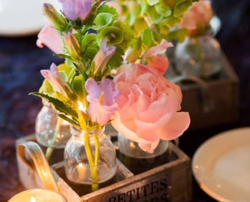 tiny bud vases in wooden carrier with pink canterbury bells, bells or ireland, peonies, votive candle at Lake Geneva wedding, Stem Cut Flowers florist, Wisconsin wedding photographer.