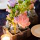 tiny bud vases in wooden carrier with pink canterbury bells, bells or ireland, peonies, votive candle at Lake Geneva wedding, Stem Cut Flowers florist, Wisconsin wedding photographer.