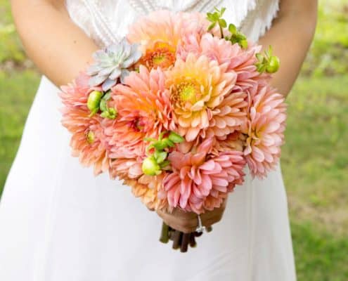 bride wearing fringed bodice wedding dress holds peach and orange wedding bouquet with succulents, Parker's Petals florist, Mohawk House, Sparta, NY wedding photographer.