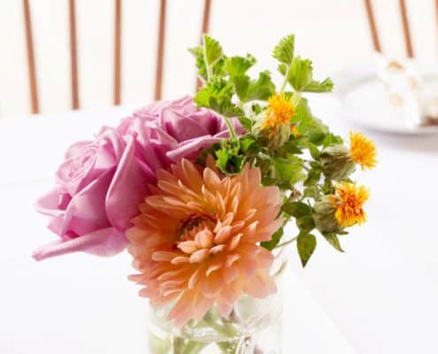 peach and pink dahlia and rose wedding table centerpiece in mason jar, white table cloth. Parkers Petals florist, Mohawk House, Sparta NY wedding photographer.