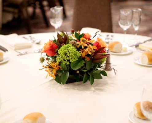 burnt orange, burgundy and green wedding table centerpiece floral arrangement, roses, white table cloth, Viburnum florist, Princeton, NJ wedding photographer.