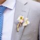 Tiny white flowers boutineer wrapped with raffia, light gray suit, blue and white small plaid tie, Molly Oliver florist, Invisible Dog Art Center, NYC wedding photographer.