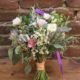 bridal bouquet on wooden ledge in front of old brick wall at Frankie's 457 Spuntino, vintage floral arrangement, white, pink, silvery leaves, purple ribbon, Opalia florist, Brooklyn, NY wedding photographer.