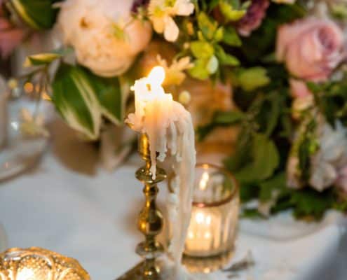 brass candlestick with dripping wax candlestick, gold and glass votive holders, pink and white wedding table flowers, peonies, roses, Quatre Coeur florist, The Water Club NYC wedding photographer.