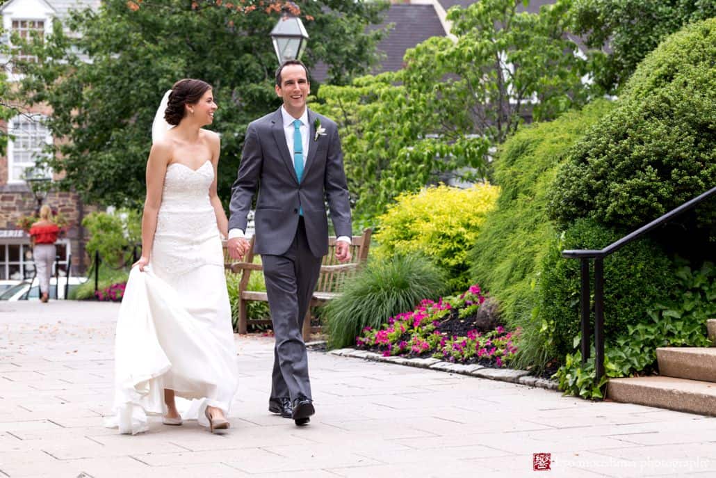 Nassau Inn wedding photos: bride and groom walk across the path in front of Princeton's historic hotel