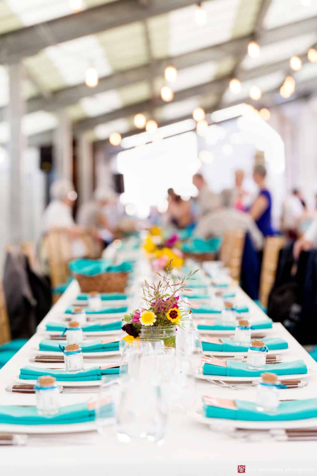 Party table with teal napkins and wildflowers at Brooklyn Grange summer wedding reception