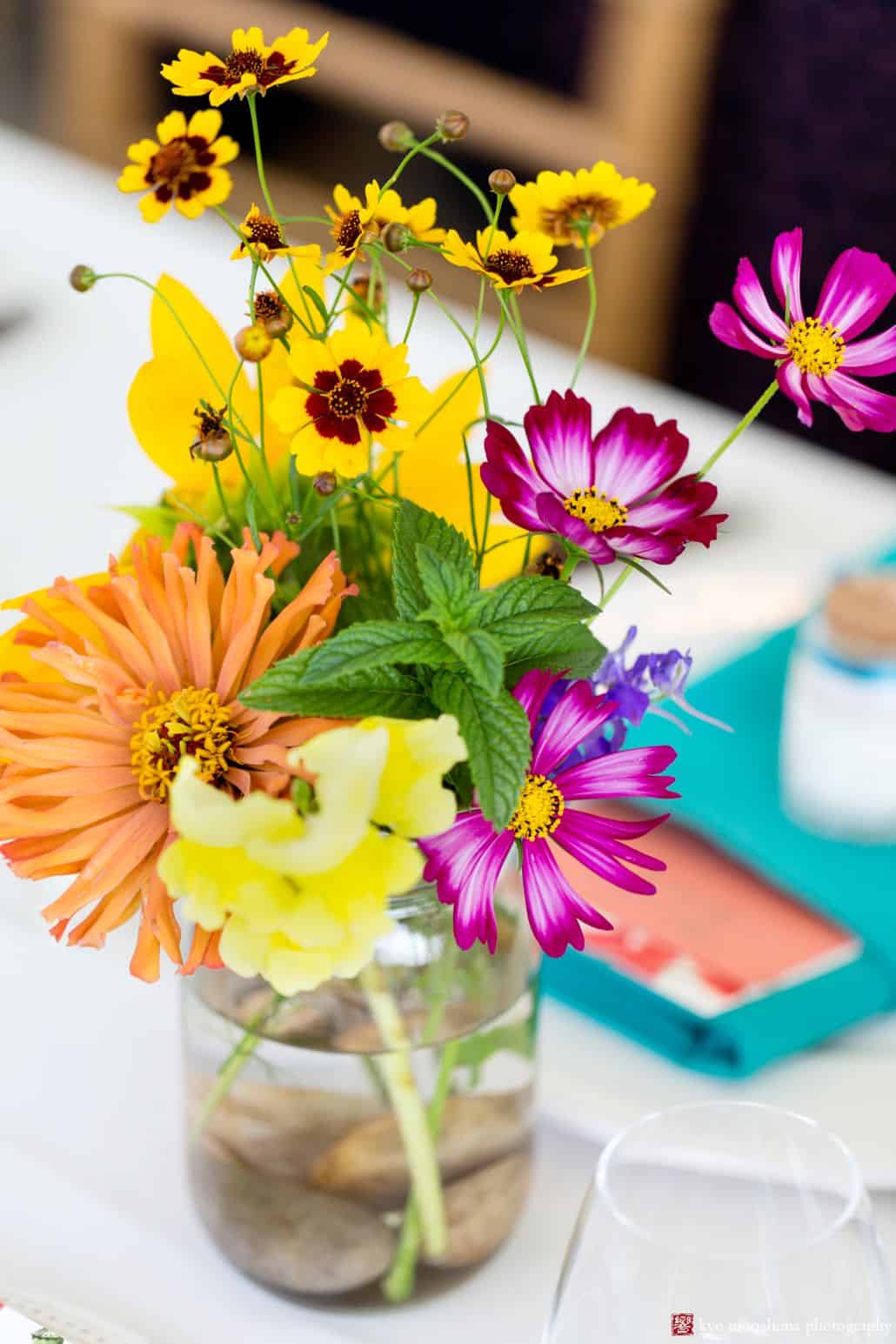 Orange, yellow, and purple wildflowers in a mason jar at Brooklyn Grange wedding