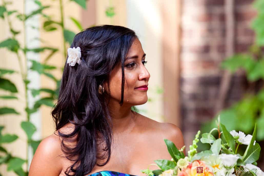 Candid wedding photo of bride's sister with tear rolling down her cheek during ceremony at Electric Anvil Tattoo in Brooklyn