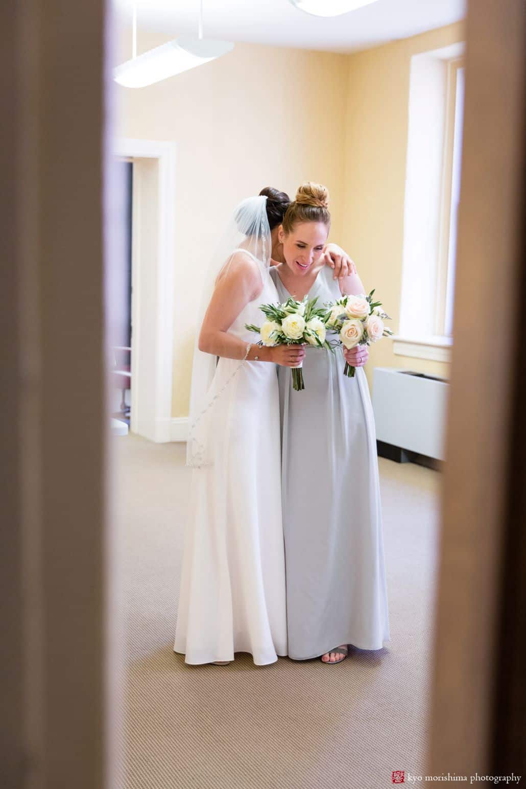 Bride and bridesmaid hug before wedding ceremony at Hunterdon County courthouse. BHLDN bridal gown, The Pod Shop flowers, New Hope, intimate wedding, PA wedding photographer.