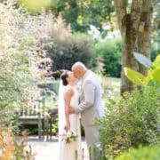 Bride and groom kiss in garden in New Hope, PA, The Pod Shop Flowers rose bouquet, Summer wedding photographer, intimate wedding.
