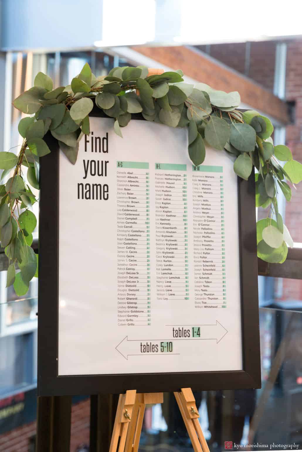 Wedding seating chart in black frame surrounded by leaves at Triumph Brewery, New Hope PA, Summer intimate wedding details photographer