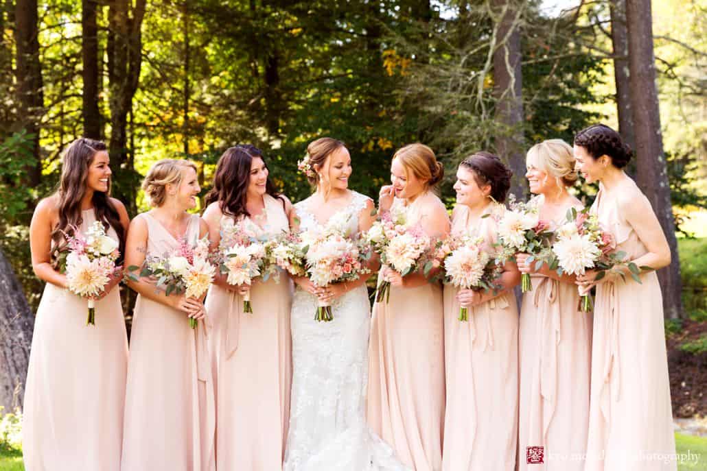 Bride and six bridesmaids gather in wooded area at Woodloch Pines in the Poconos, sand colored chiffon bridesmaids dresses by Nouvelle Amsale, Castle Couture bridal gown, pale pink dahlia, eucalyptus bouquets by Fox Hill Farm Experience, outdoor wedding photographer.