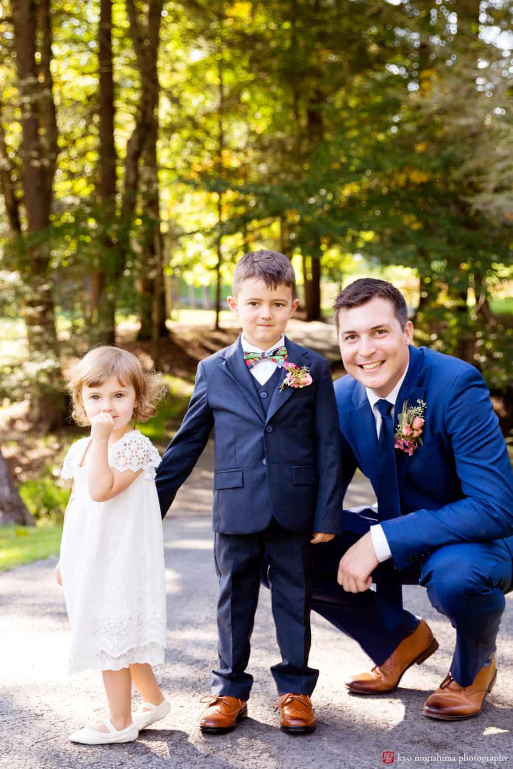 Groom poses with ring bearer and flower girl along wooded path in Woodloch Pines, cute wedding pictures, ourtood wedding photography ideas, Poconos wedding photographer. Woodloch Pines wedding.