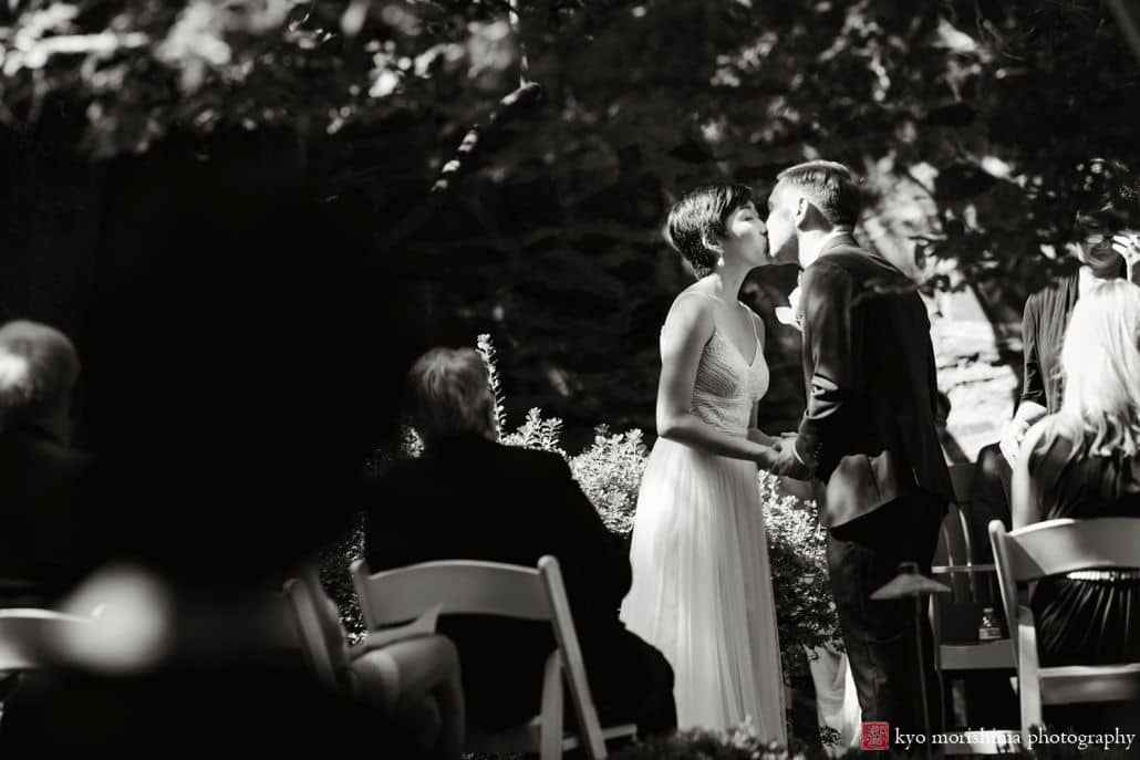 Bride and groom kiss during high noon ceremony at unique small wedding venue Carlyle House in Old Town Alexandria.