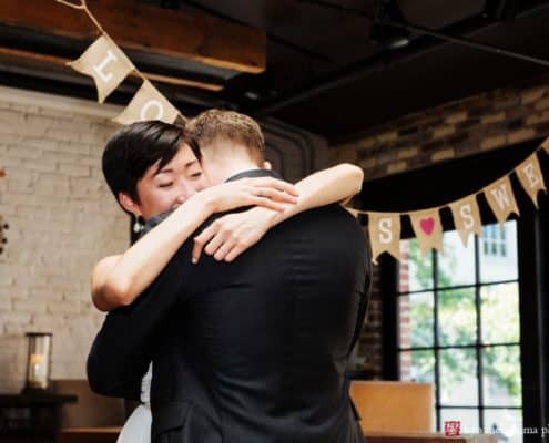 Bride and groom have an emotional embrace during first dance at Virtue Feed and Grain wedding, by photojournalistic wedding photographer Kyo Morishima