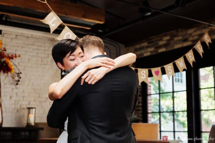Bride and groom have an emotional embrace during first dance at Virtue Feed and Grain wedding, by photojournalistic wedding photographer Kyo Morishima