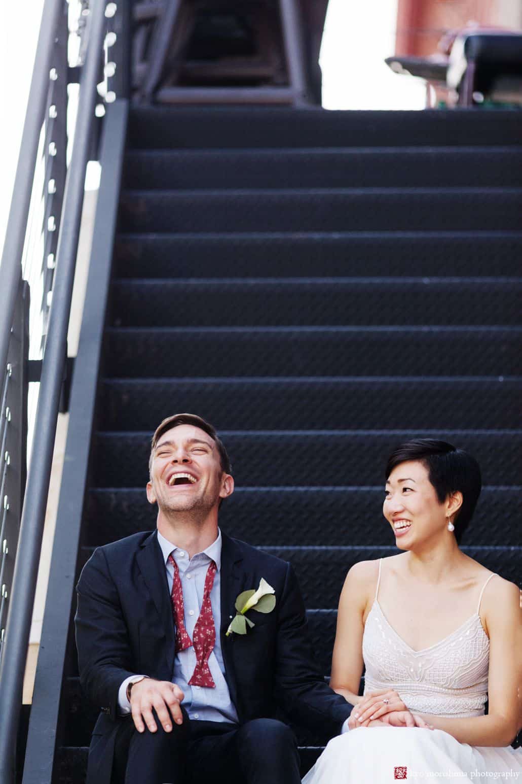 Fun wedding photo of bride and groom sitting on fire escape steps outside Virtue Feed and Grain in Old Town Alexandria