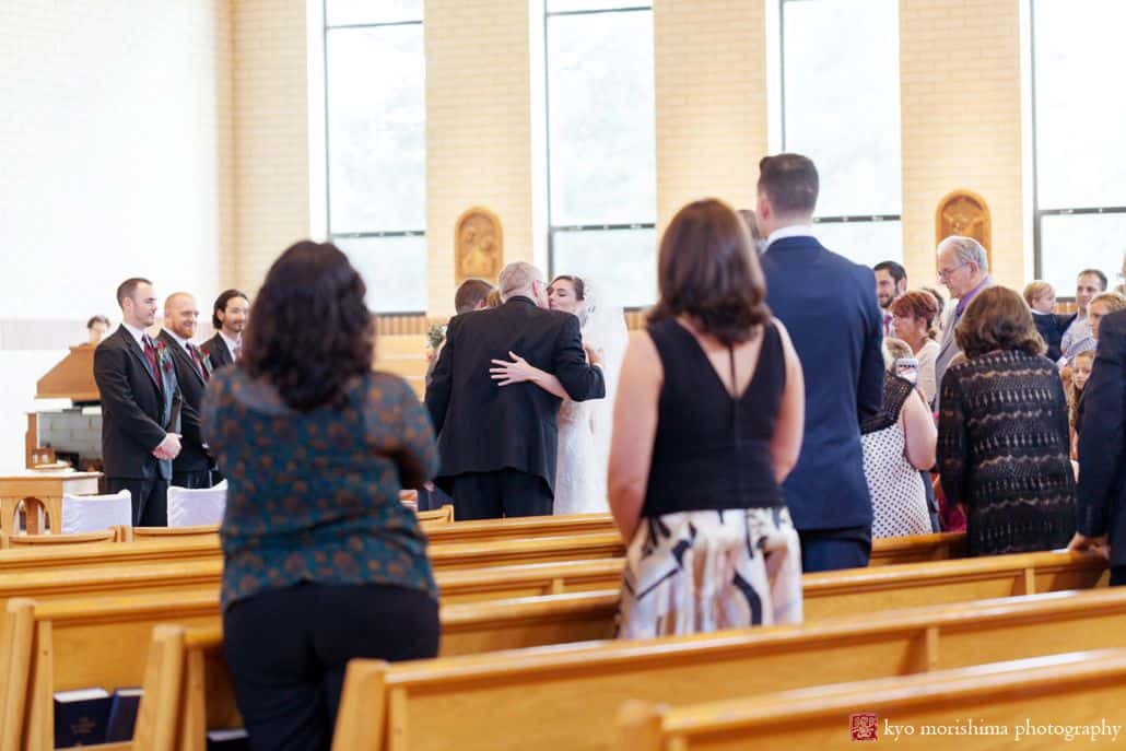 Bride hugs parents during St. Magdalen Church wedding in Flemington, NJ