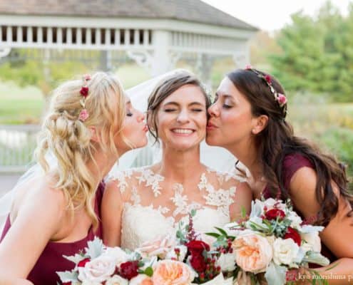 Wedding poses examples: bridesmaids kiss bride in front of gazebo at Chauncey Hotel and Laurie House Garden Pavilion wedding, Princeton, NJ