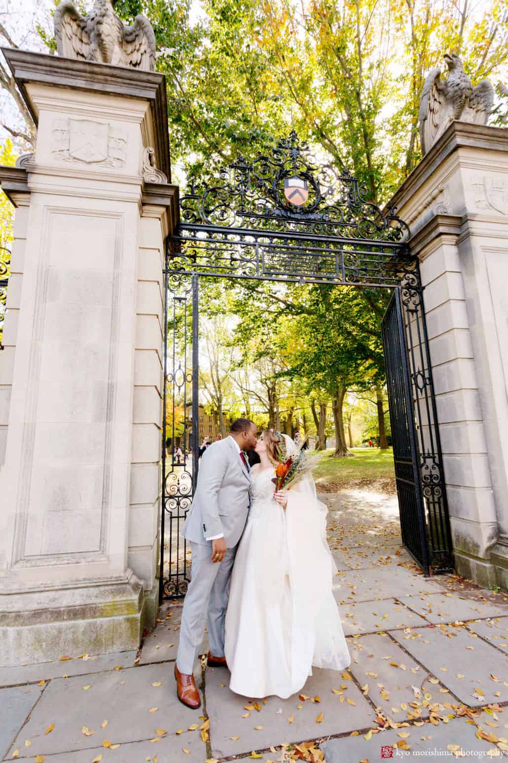 First wedding day kiss in front of Nassau Hall gates at Princeton University; fall wedding 