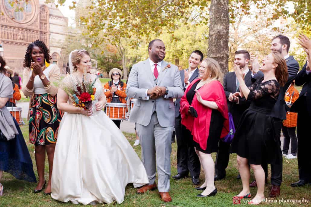 Bride and groom laugh with guests on Princeton University quad after October ceremony