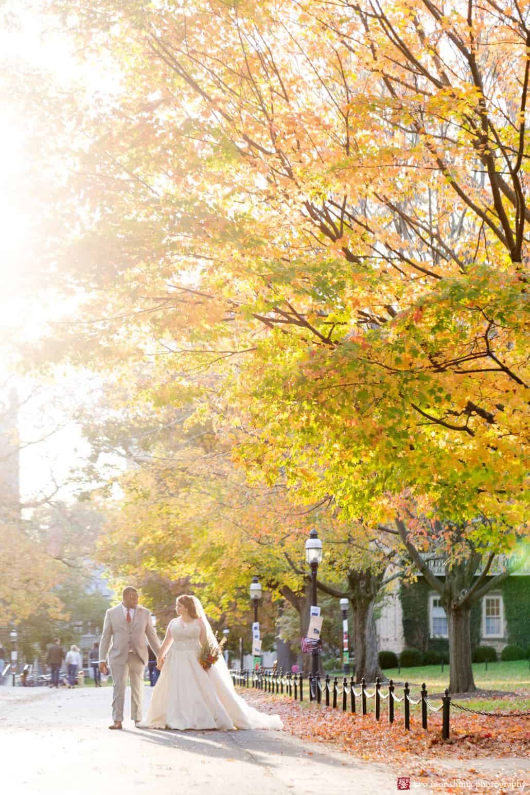 Wedding portrait with fall leaves; bride and groom enjoy a walk down the street on Princeton University campus