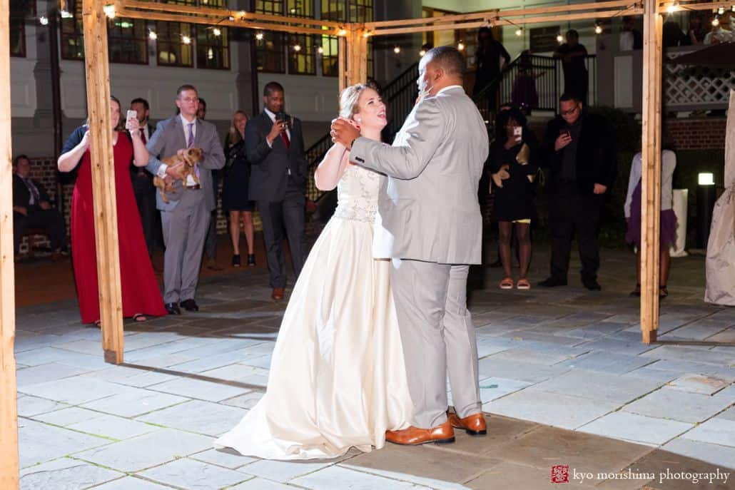 Bride and groom dance on stone pavilion with bulb string lights during October wedding at Princeton University Cap and Gown club