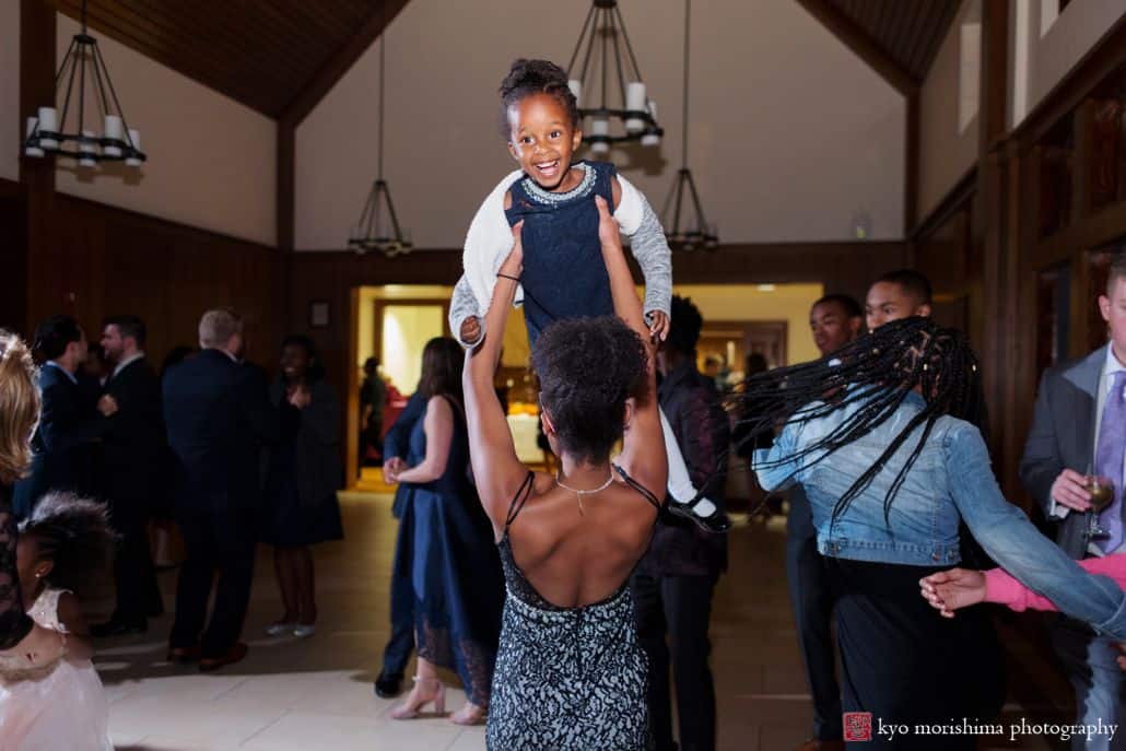 Wedding guest lifts child into the air during dancing at Princeton University Cap and Gown Club