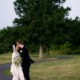 Bride and groom kiss on a path outside Mercer Oaks Country Club with thunderstorm approaching. West Windsor Township, NJ.