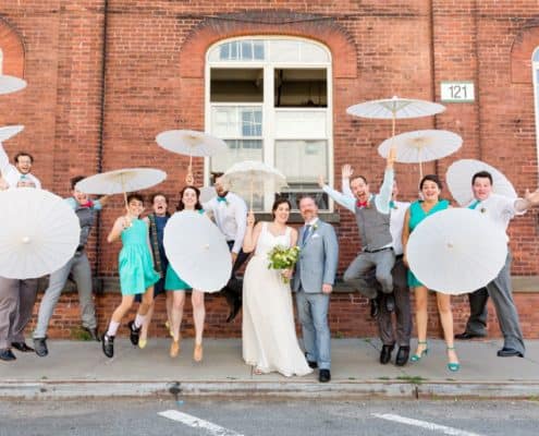 Fun wedding party portrait ideas: jumping with parasols at Brooklyn Navy Yard