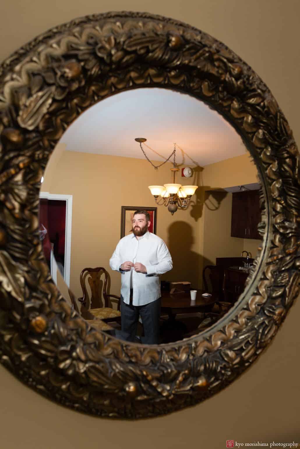 Groom gets ready, reflected in convex round mirror at Nassau Inn, Princeton