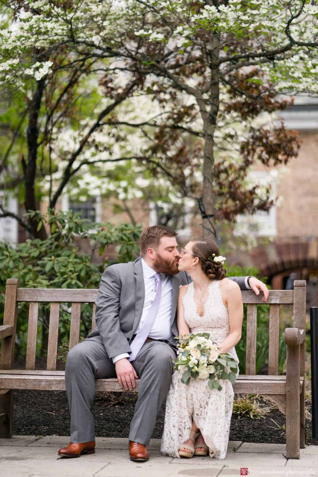 Bride and groom kiss in Palmer Square outside the Nassau Inn; bride wears BHLDN gown and carries bouquet from Bloominous