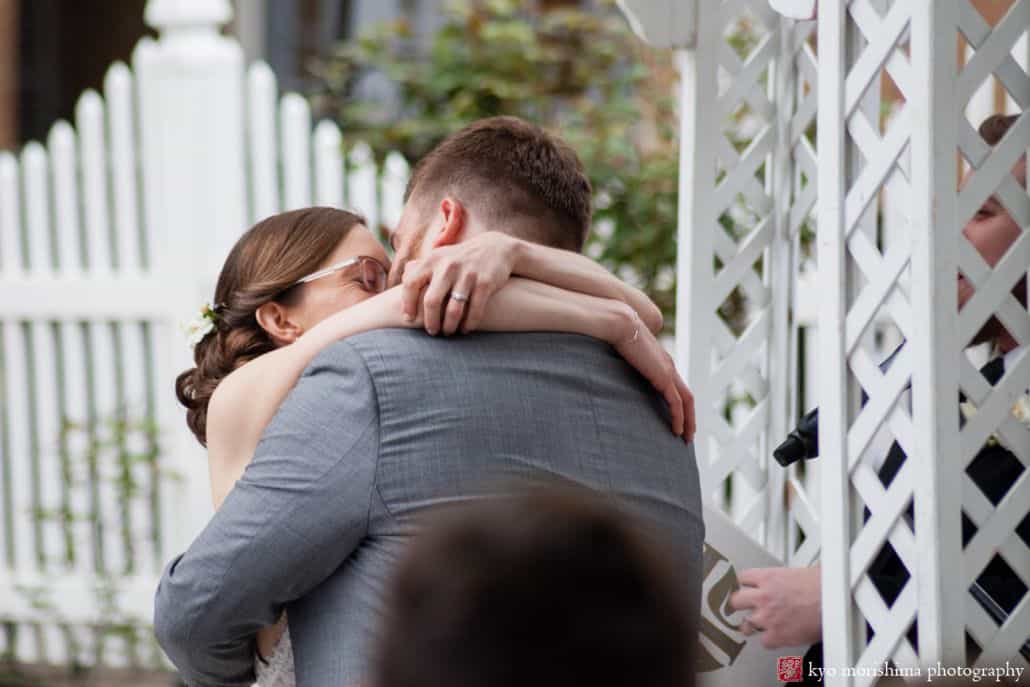 Bride and groom kiss during outdoor ceremony at Nassau Inn in May