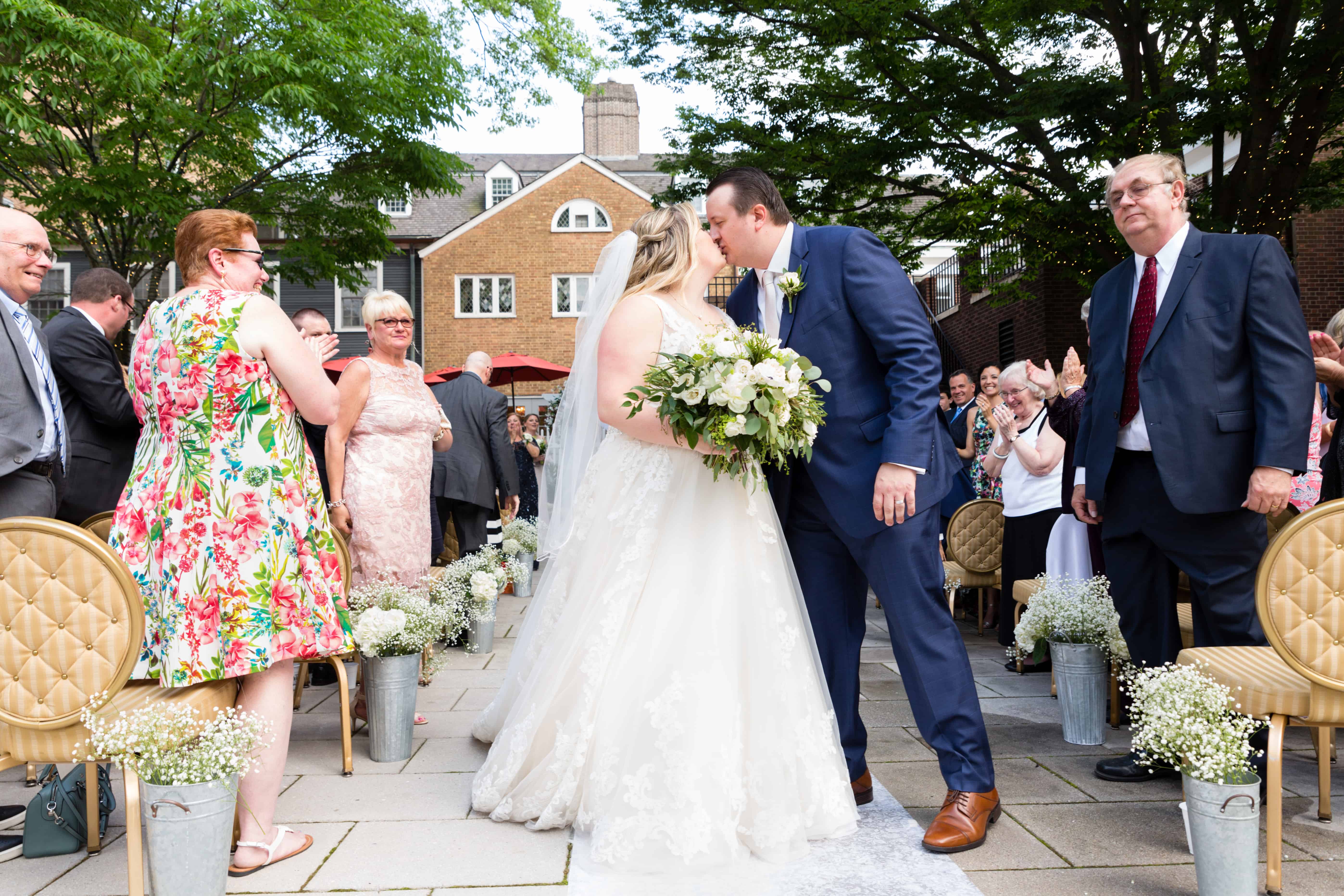 Post-wedding aisle kiss at Nassau Inn back patio wedding