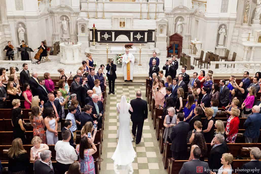 Bride walks down the aisle at the beginning of St. Peter's NYC wedding