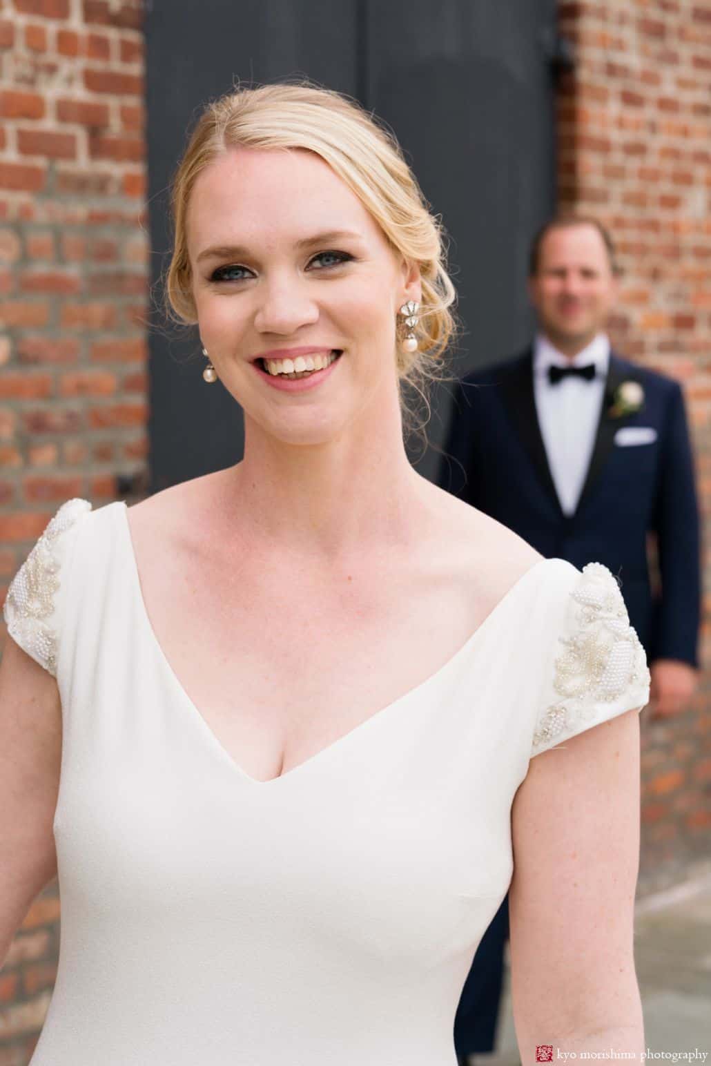 Wedding poses ideas: bride in foreground with groom behind her, shallow depth of field (photo taken in Red Hook Brooklyn)