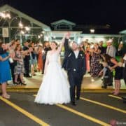 bride and groom holding hands in the air guests cheeping outside wedding venue night wedding picture cute and candid wedding picture ideas