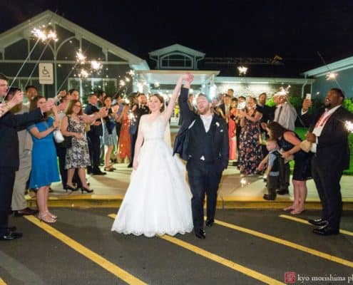 bride and groom holding hands in the air guests cheeping outside wedding venue night wedding picture cute and candid wedding picture ideas