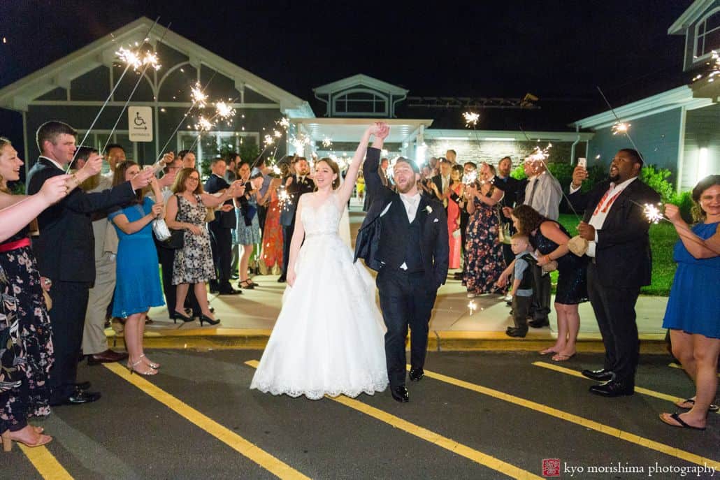bride and groom holding hands in the air guests cheeping outside wedding venue night wedding picture cute and candid wedding picture ideas Late Spring Mercer County Boathouse NJ Wedding sparkler send out 