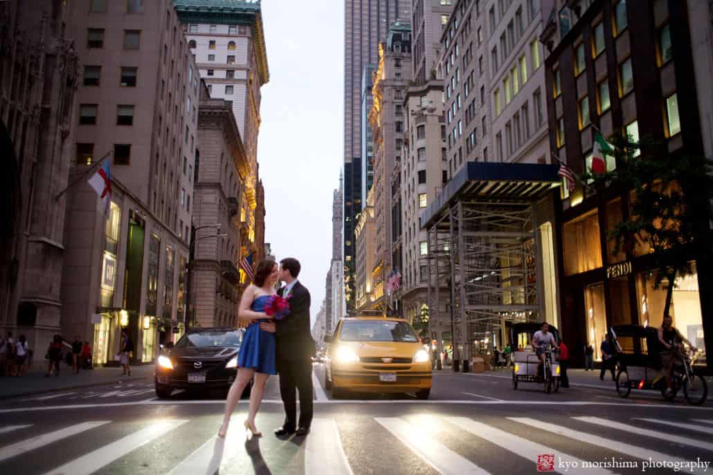  Light-hearted portrait session of the bride and groom kissing, in the middle of the street, pedestrian lane, with cars and buildings as their background photographed by NYC wedding photographer Kyo Morishima. 